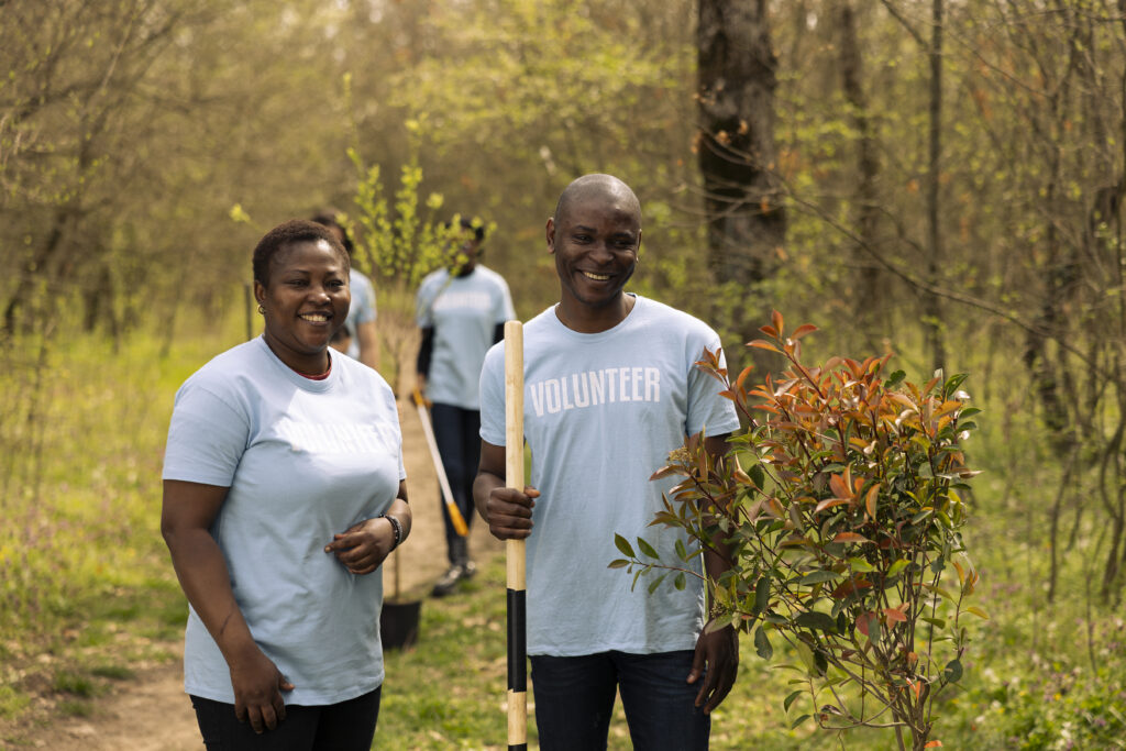 portrait of a couple volunteering to plant trees and collect garbage from the forest